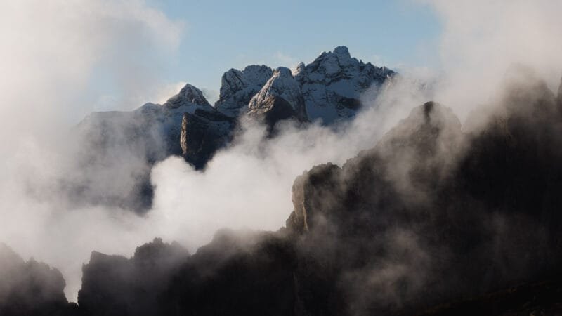 Obtenez le tirage "Crêtes fantasmées" de crêtes rocheuses enneigées au milieu des nuages