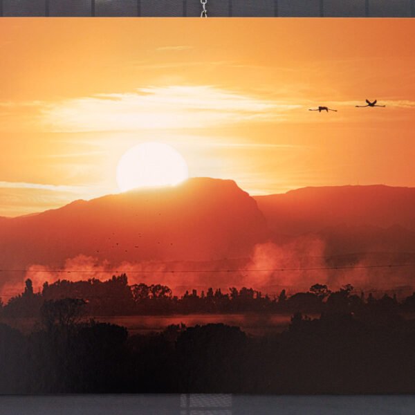 Tirage d'Art 40x60cm "Cieux embrasés" d'un coucher de soleil derrière un paysage embrumé avec des flamants roses volants